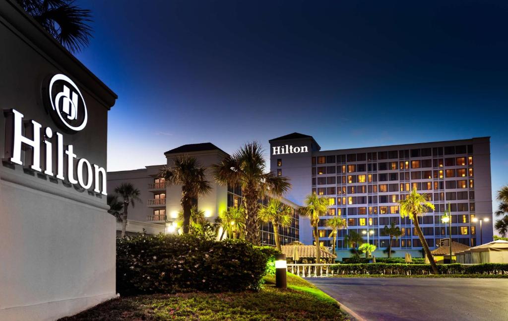 a hotel with a hilton sign in front of a building at Hilton Galveston Island Resort in Galveston