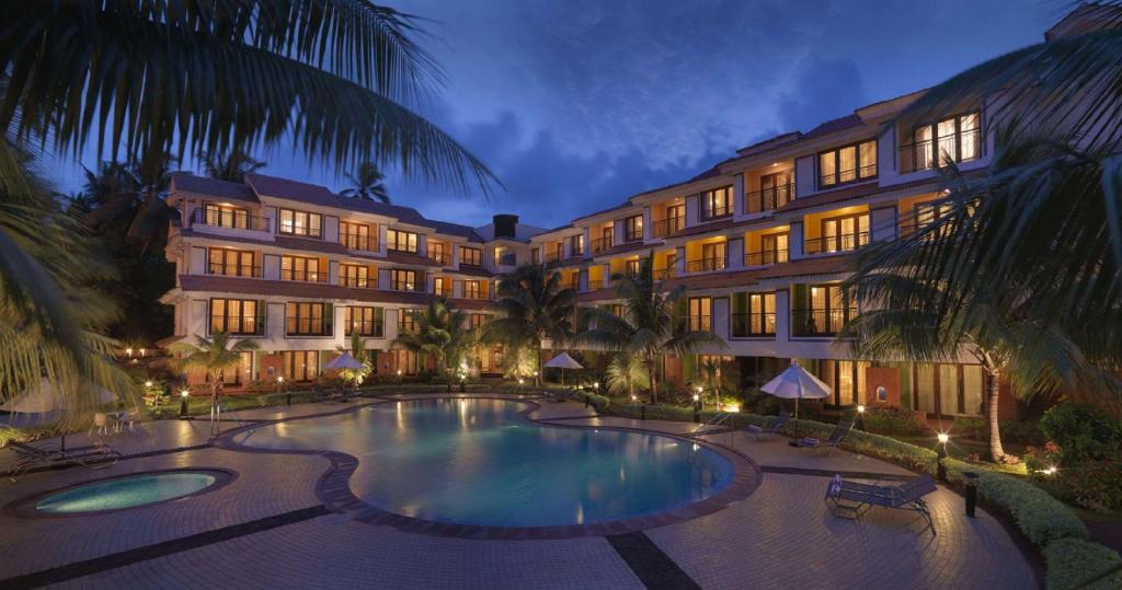 un hotel con piscina frente a un edificio en DoubleTree by Hilton Hotel Goa - Arpora - Baga, en Baga