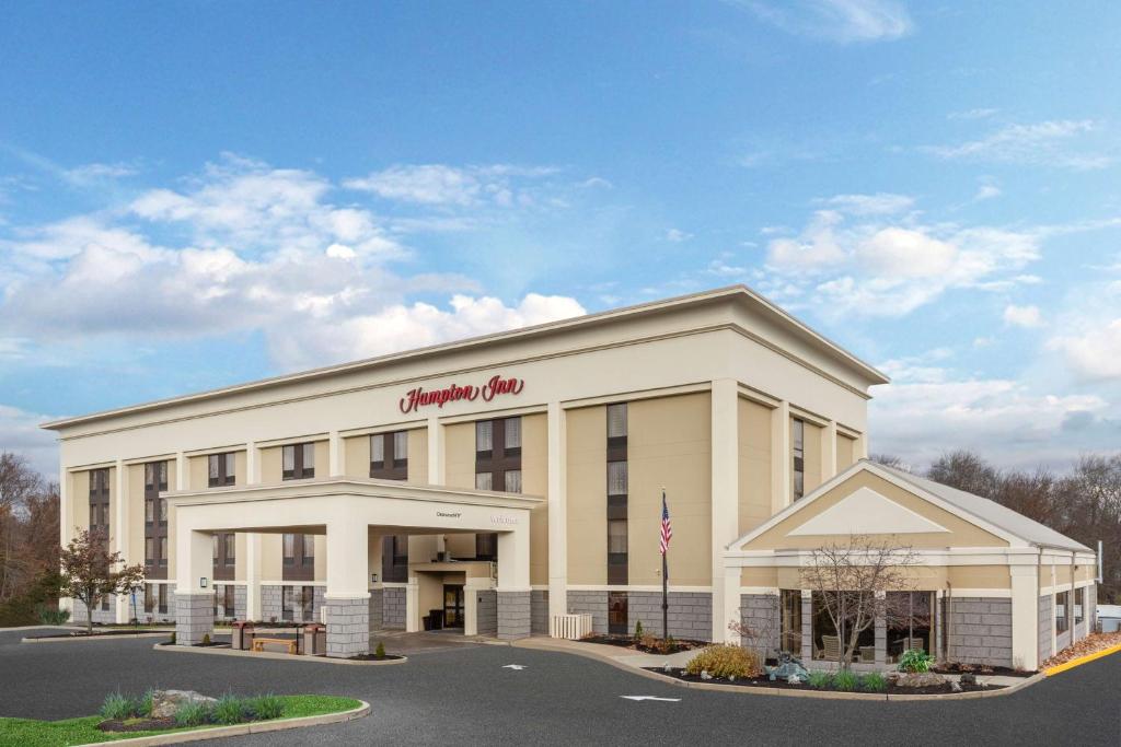 a large white building with a sign on it at Hampton Inn Groton/Mystic in Groton