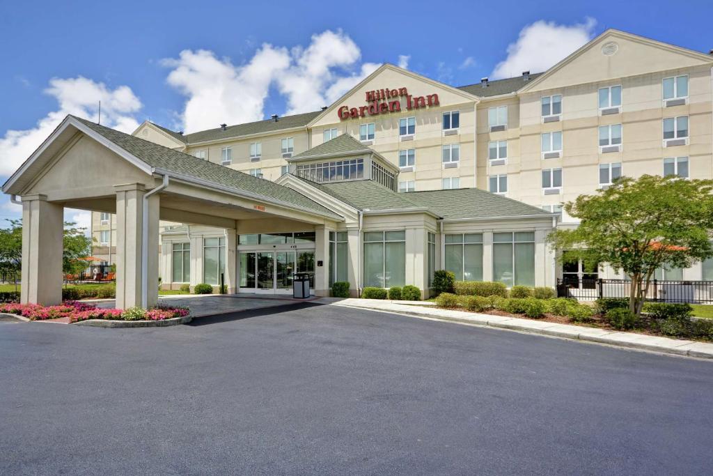 una representación de la parte delantera de un hotel con aparcamiento en Hilton Garden Inn Gulfport - Biloxi Airport en Gulfport