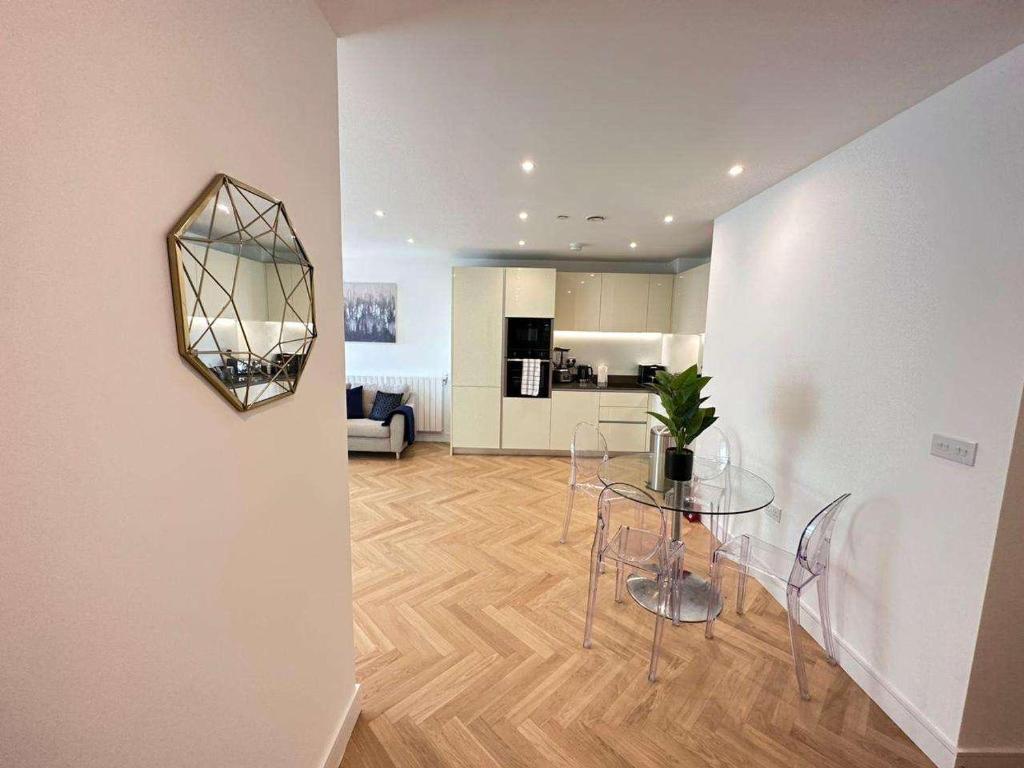ein Wohnzimmer mit einem Tisch und einer Küche in der Unterkunft Spacious one bedroom luxury apartment in Kidbrooke Greenwich in London