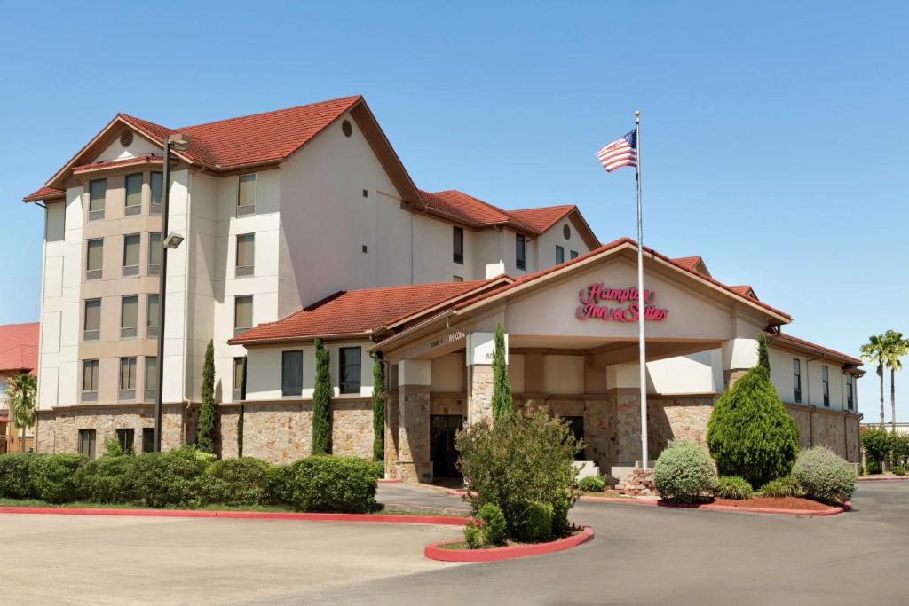 a hotel with an american flag in front of it at Hampton Inn and Suites Houston Clear Lake NASA in Webster