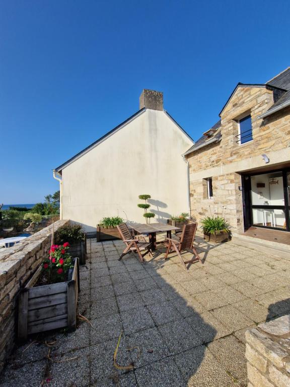 a patio with a table and chairs in front of a building at Maison en pierre accès 5 mn à pied plage in Arzon