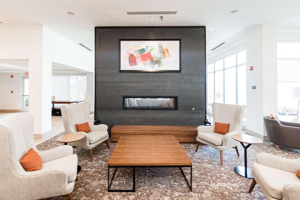 a living room with chairs and a fireplace at Hilton Garden Inn Fairfax in Fairfax