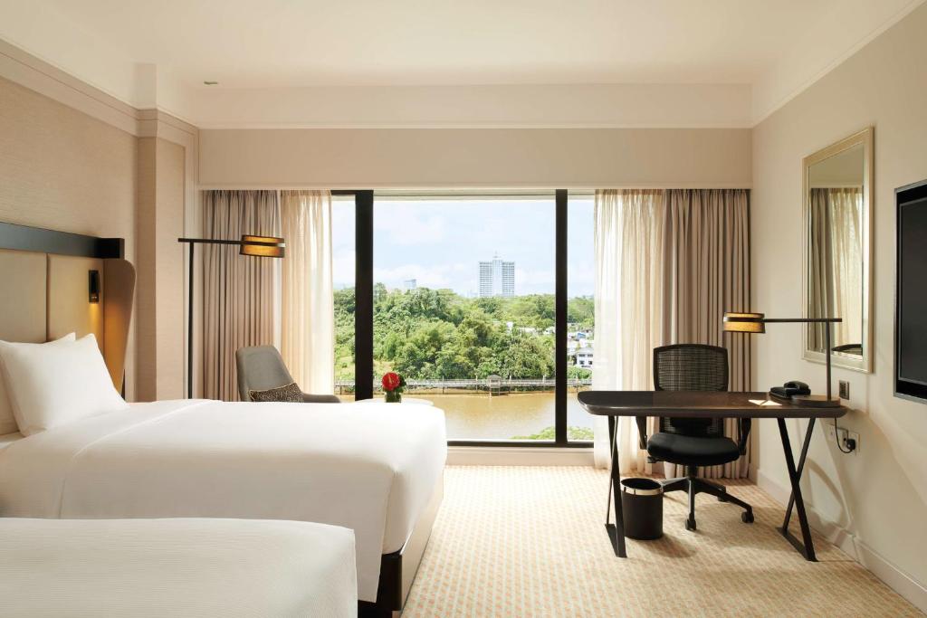 Postel nebo postele na pokoji v ubytování Hilton Kuching Hotel