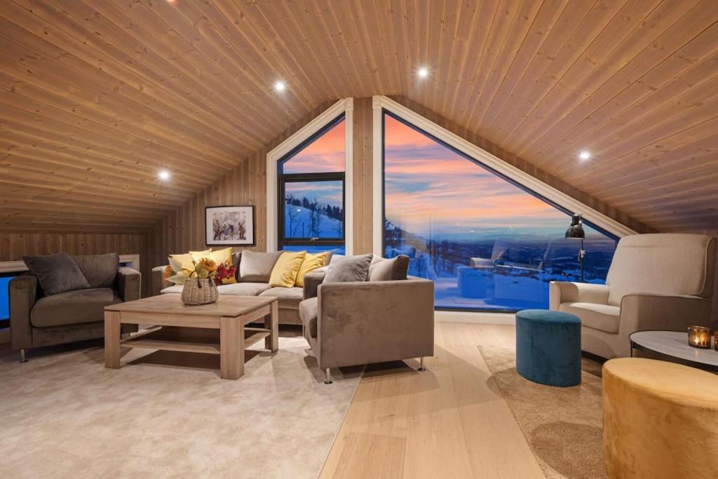 sala de estar con sofás y ventana grande en New lovely cabin in Rauland, ski inout, fast wifi en Torvetjørn