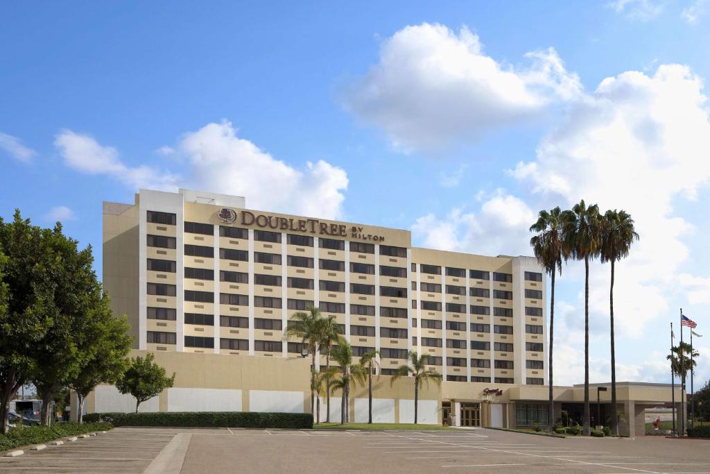 a hotel building with palm trees in front of it at DoubleTree by Hilton Los Angeles Norwalk in Norwalk