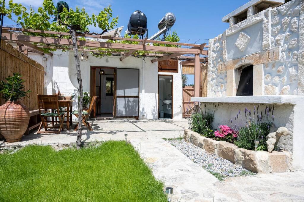 a stone house with a patio and a yard at Finikas House in Palekastron