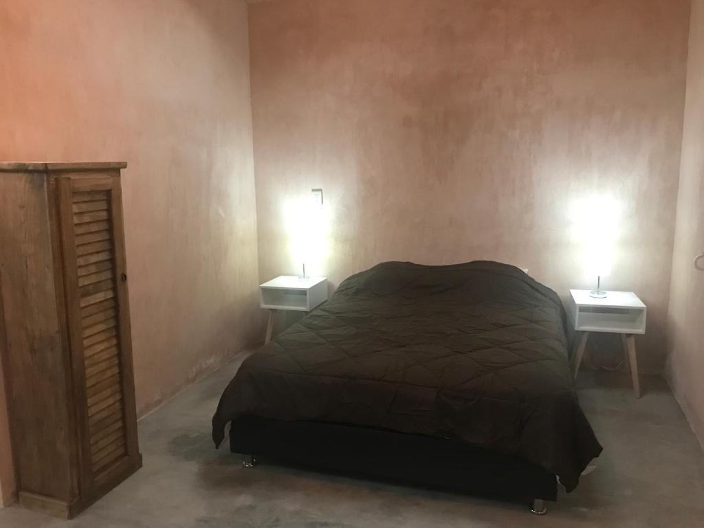 a bedroom with a bed and two lights on two tables at Quinta Lum in San Cristóbal de Las Casas