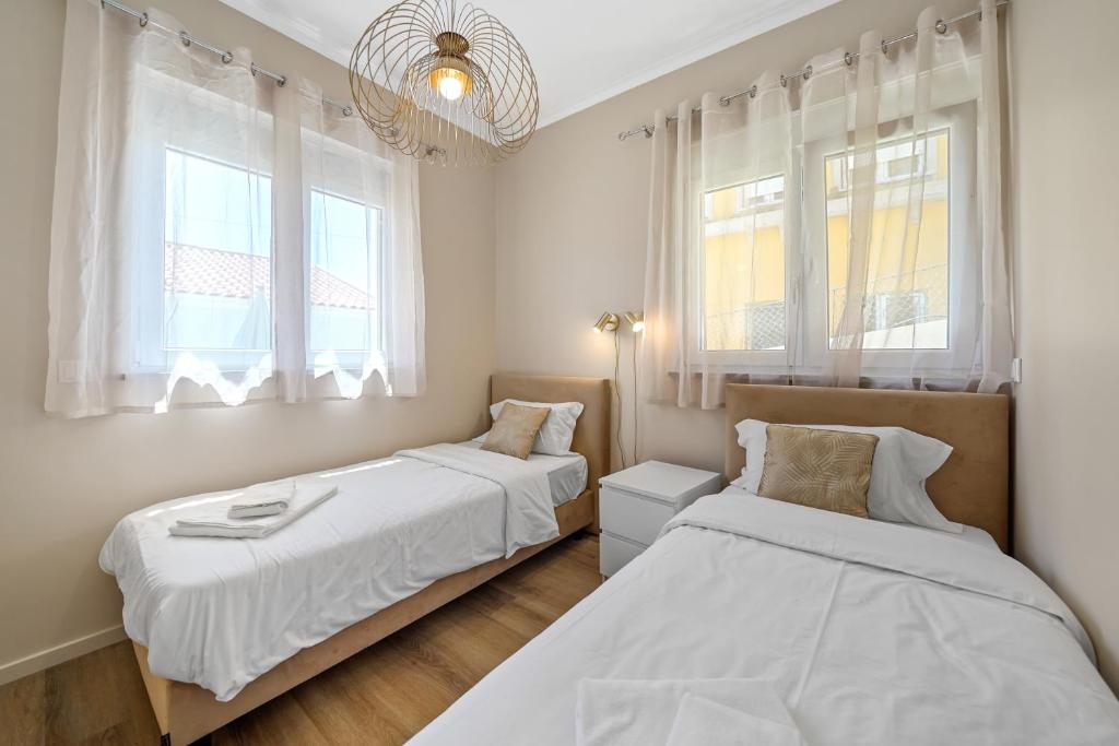 two beds in a room with two windows at Fully Renovated Apartments Luiz I Bridge I by Amber Star in Vila Nova de Gaia