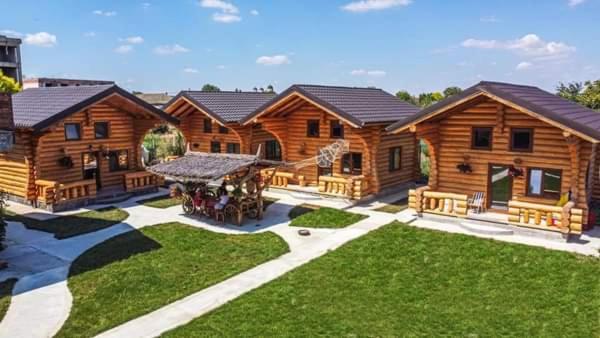 a large log cabin with a grill in the yard at CASUTELE VADULUI in Vadu
