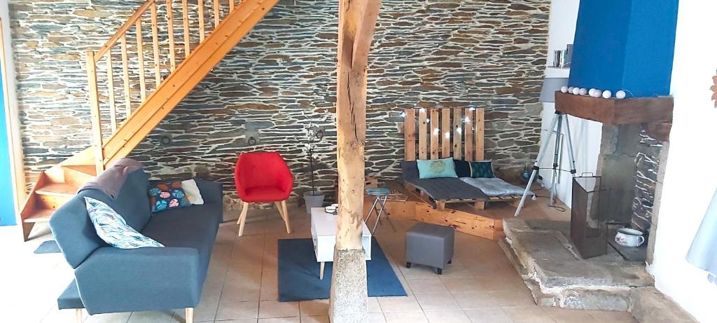 a living room with a couch and a brick wall at Les hortensias de Stéfanick in Mûr-de-Bretagne