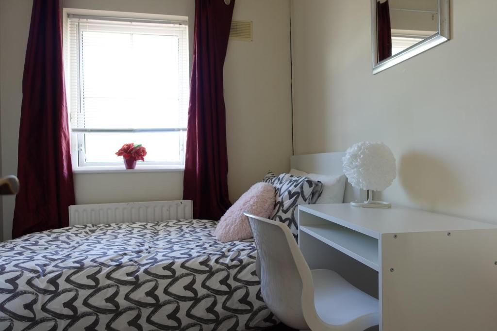 a bedroom with a bed and a desk and a window at Females Only - Private Bedrooms in Dublin in Lucan