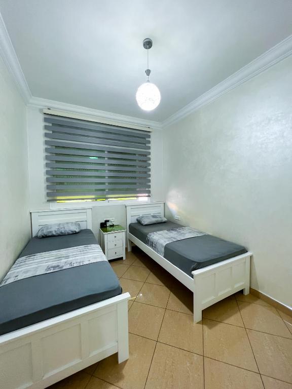 a bedroom with two beds and a window at Rif Appartment in Al Hoceïma