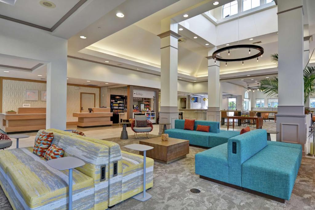 a large lobby with blue couches and tables at Hilton Garden Inn Orlando Lake Buena Vista in Orlando