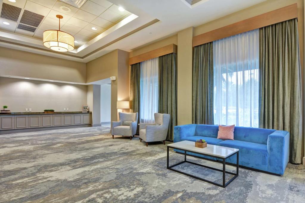 a lobby with a blue couch and chairs and a table at Hilton Garden Inn Orlando Lake Buena Vista in Orlando