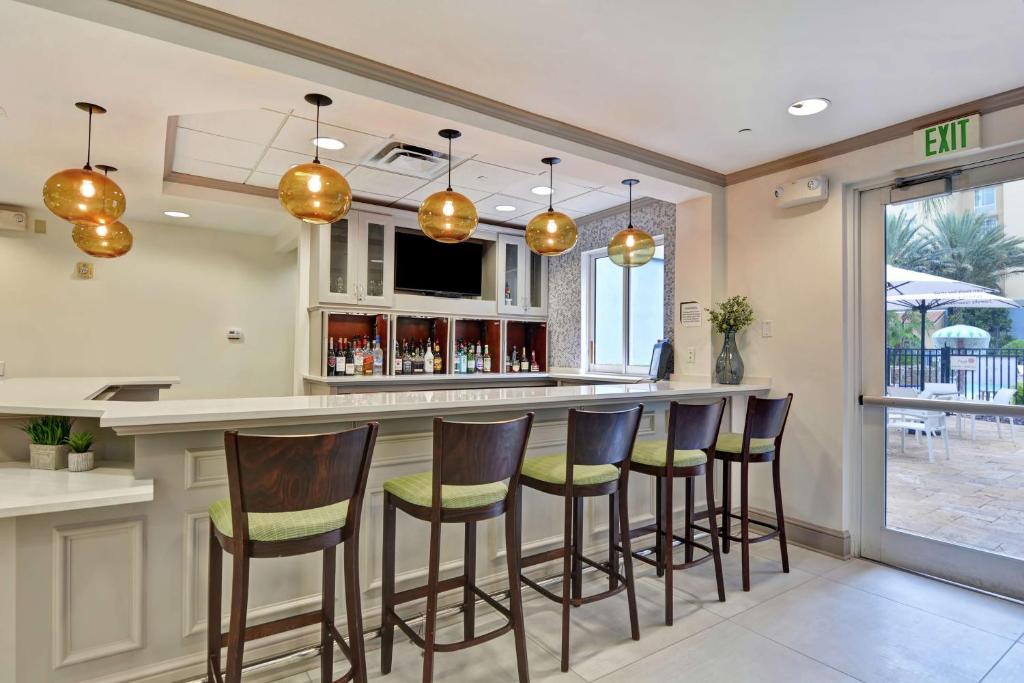 a bar with stools in a kitchen with a patio at Hilton Garden Inn Orlando Lake Buena Vista in Orlando