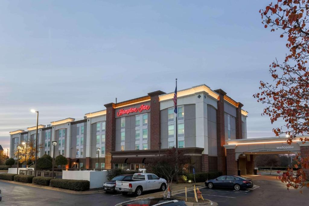 un gran edificio con coches estacionados en un estacionamiento en Hampton Inn Memphis-Southwind, en Memphis