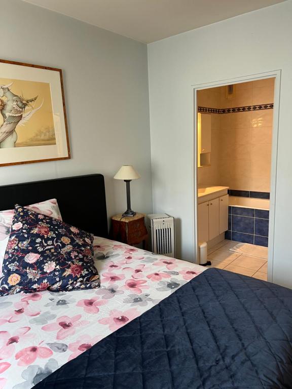 Un dormitorio con una cama con un edredón azul con flores. en Appartement Chevaleret, en París