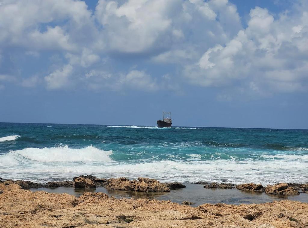 a boat in the ocean with rocks in the water at Coral View in Peyia