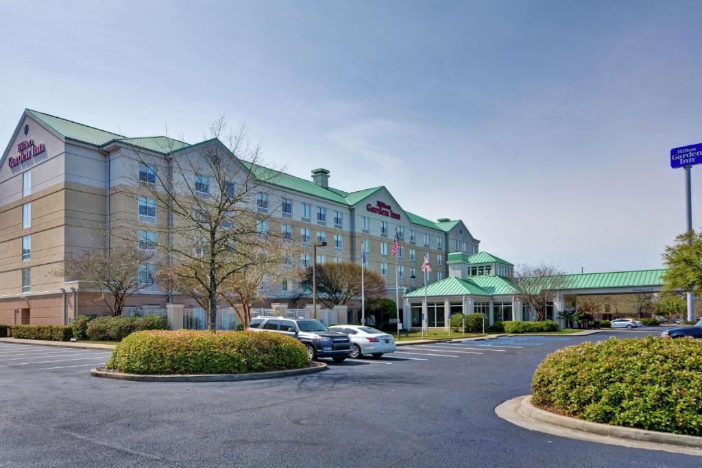 ein großes Gebäude mit Autos auf einem Parkplatz in der Unterkunft Hilton Garden Inn Mobile East Bay / Daphne in Daphne