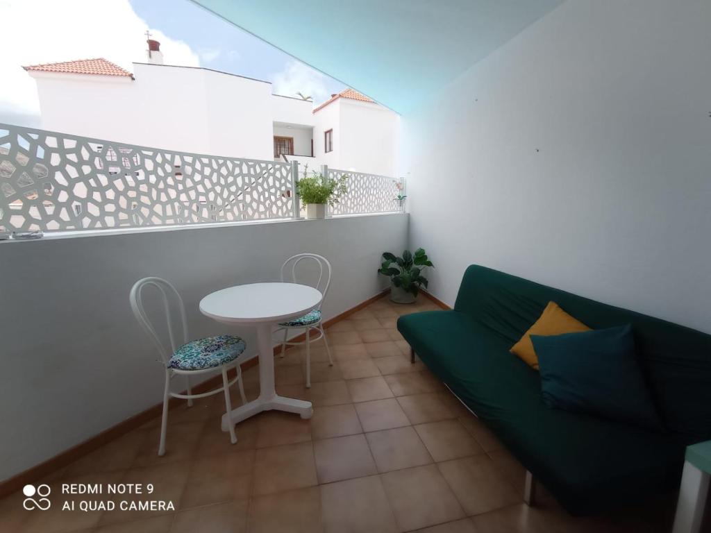 a living room with a green couch and a table at Tenerife Sweet Home, Cheap and Clean, Pool, Beach, WiFi, Quite in Los Cristianos