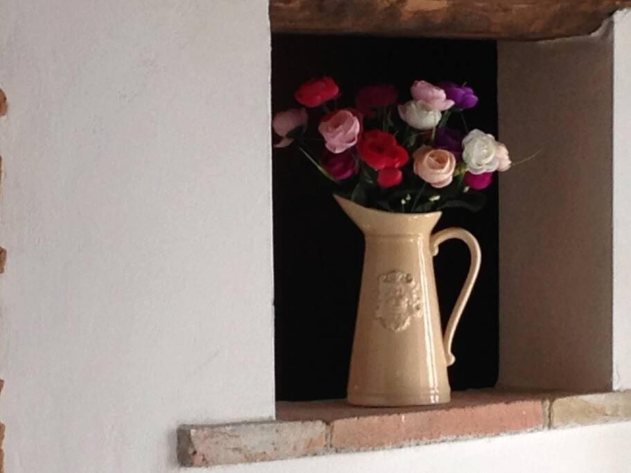 un jarrón lleno de flores sentado en una cornisa en LA CASA DEI POETI - C.I.R. 054039LOTUR19934, en Perugia