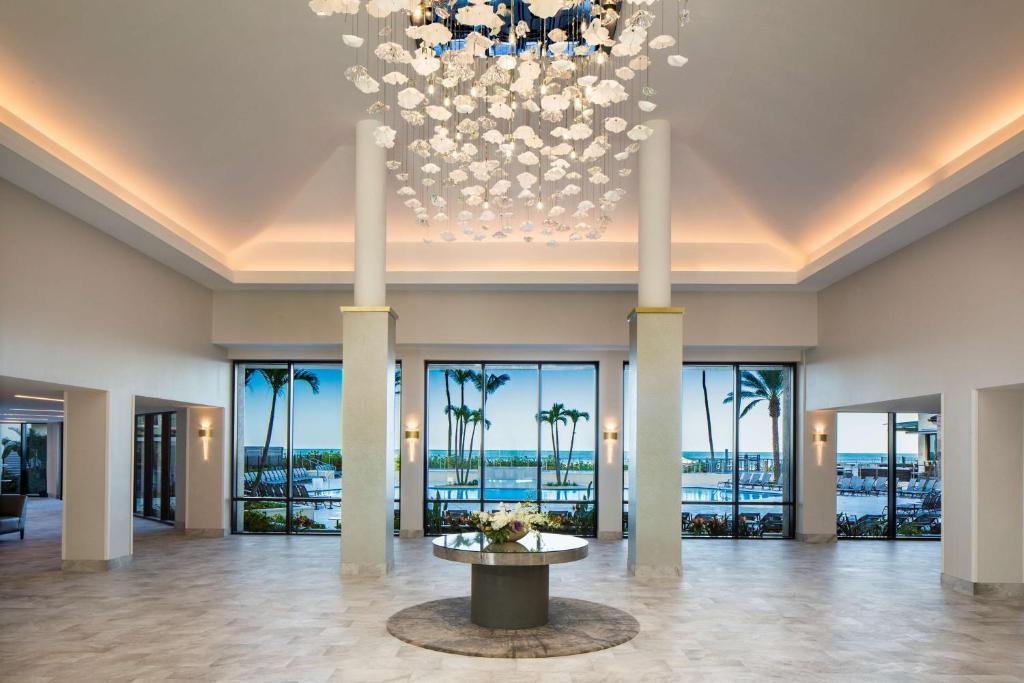 un grand hall avec un lustre et des palmiers dans l'établissement Hilton Marco Island Beach Resort and Spa, à Marco Island