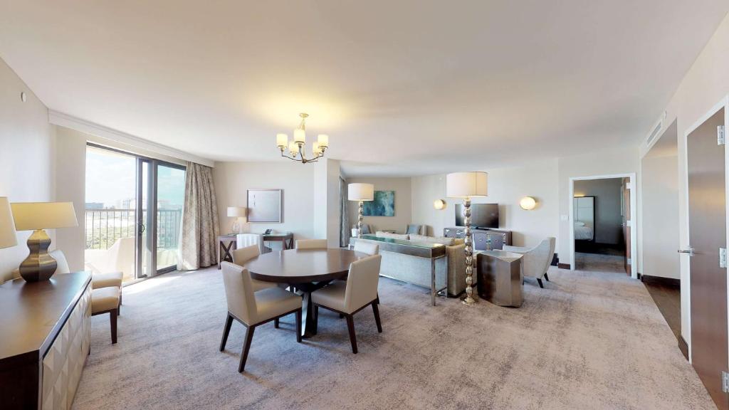 a living room with a table and chairs and a couch at Hilton Marco Island Beach Resort and Spa in Marco Island