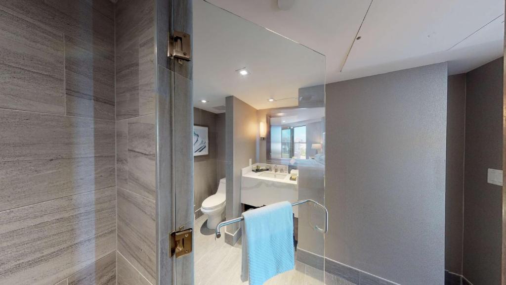 a bathroom with a shower and a toilet and a sink at Hilton Marco Island Beach Resort and Spa in Marco Island