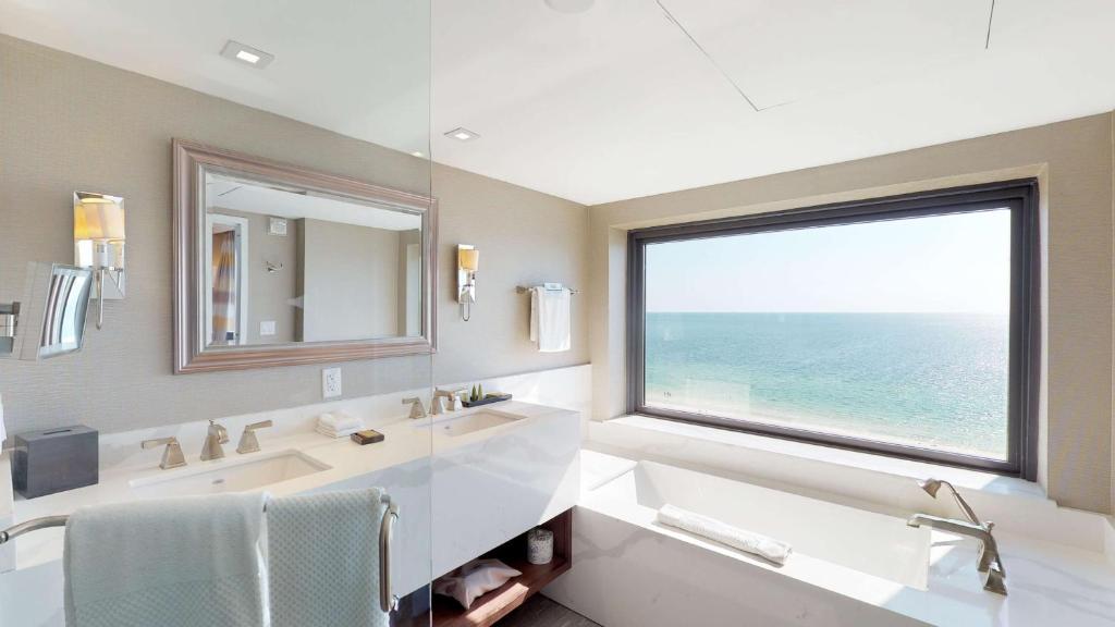 a bathroom with a sink and a large window at Hilton Marco Island Beach Resort and Spa in Marco Island
