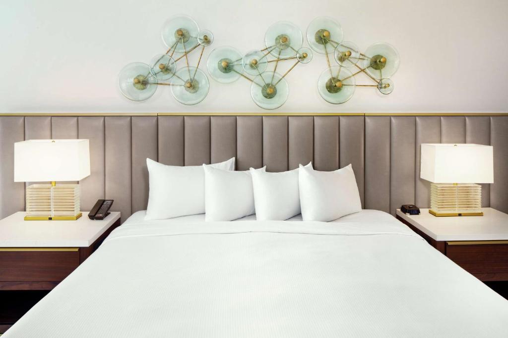a bedroom with a large white bed with two lamps at Hilton Marco Island Beach Resort and Spa in Marco Island