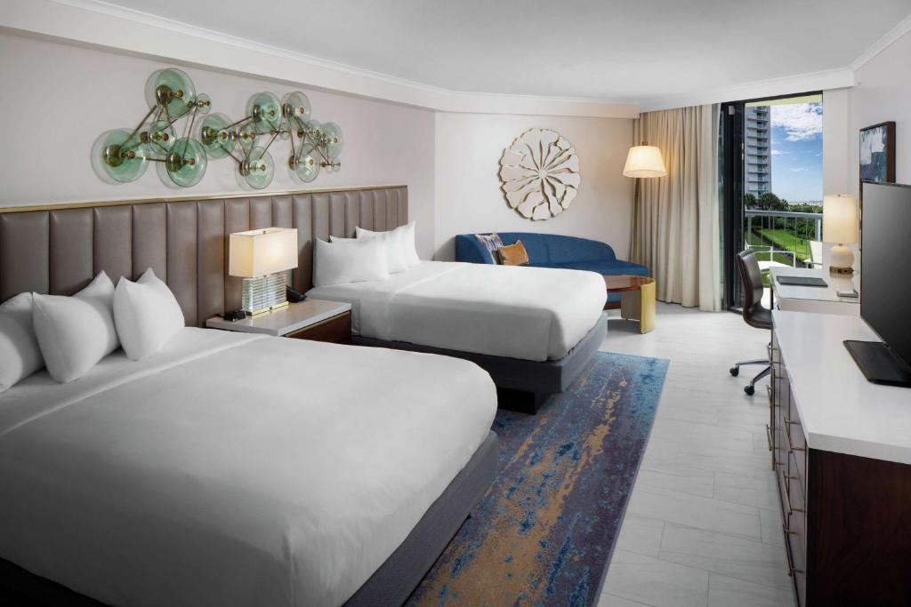 a hotel room with two beds and a kitchen at Hilton Marco Island Beach Resort and Spa in Marco Island
