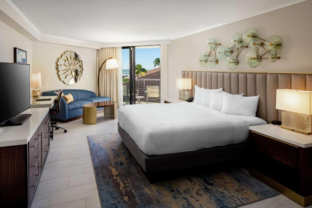 a hotel room with a bed and a television at Hilton Marco Island Beach Resort and Spa in Marco Island