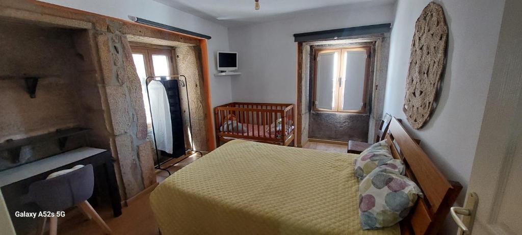 a bedroom with a bed with a yellow bedspread at Benedita's House in Capinha