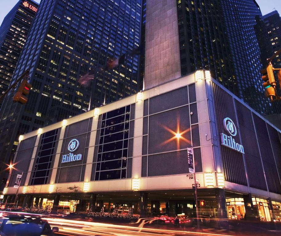 a large building with a sign on it in a city at Hilton Club New York in New York