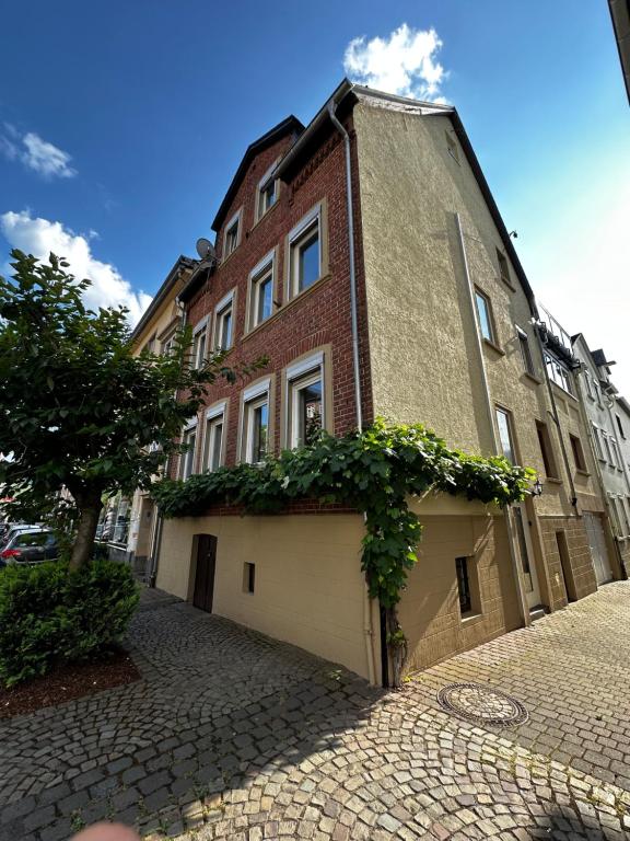 a large brick building on a cobblestone street at Ferienhaus Zur Gasse in Zell an der Mosel