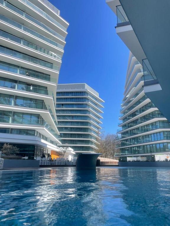 two tall buildings next to a body of water at Wave Prestige Studio - Sea View - SPA&Pools in Międzyzdroje