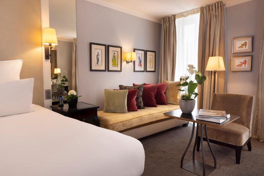 um quarto de hotel com uma cama e um sofá em La Villa Madame em Paris