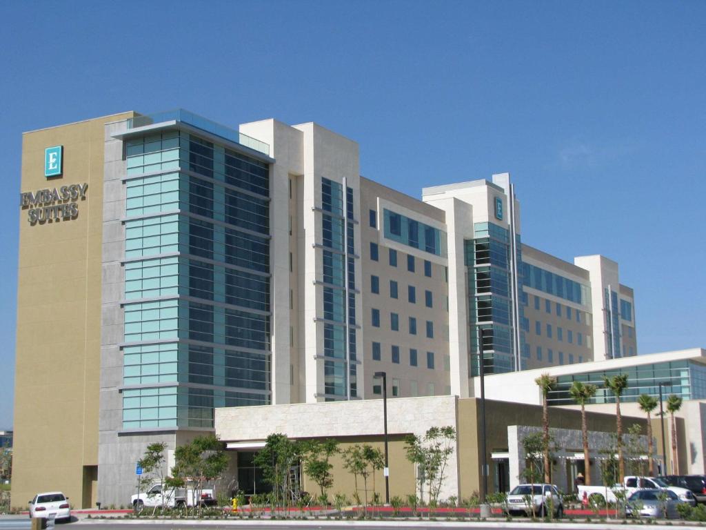 オンタリオにあるEmbassy Suites Ontario - Airportの車が目の前に停まった大きな建物