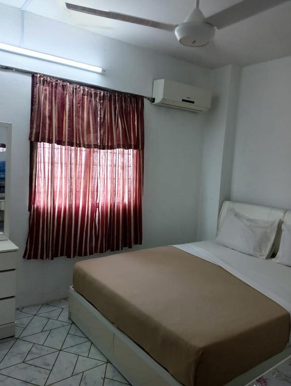 a bedroom with a bed and a red window at KHAIRUL HOMESTAY SEBERANG JAYA in Kampong Telok