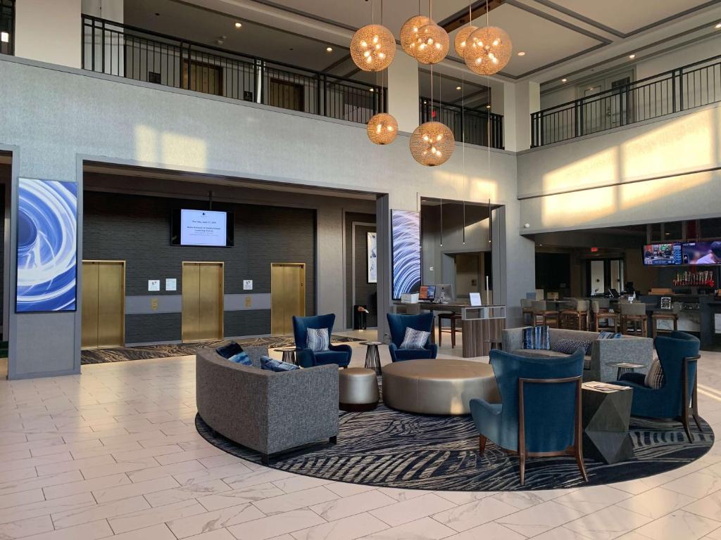 a hotel lobby with a waiting area with blue chairs at DoubleTree Suites by Hilton Hotel & Conference Center Chicago-Downers Grove in Downers Grove