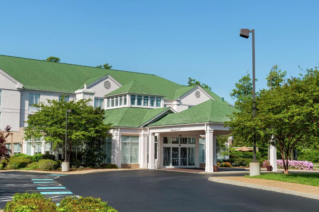 een groot huis met een groen dak bij Hilton Garden Inn Newport News in Newport News