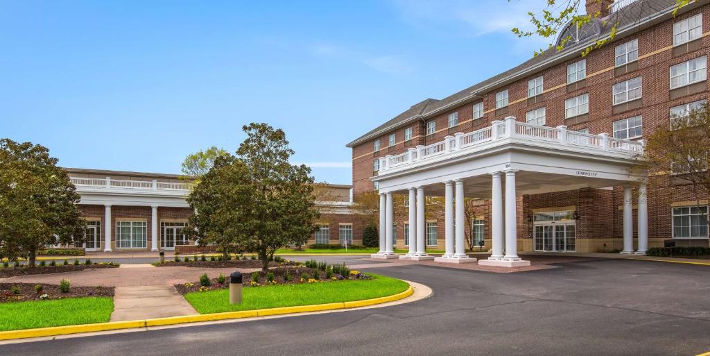 un gran edificio de ladrillo con un porche blanco en Hilton Garden Inn Suffolk Riverfront, en Suffolk