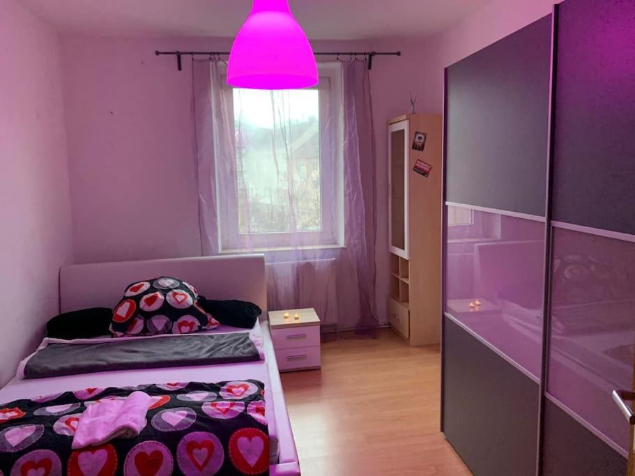 um quarto roxo com duas camas e uma luz rosa em Apartments - 3 rooms, 3-5 person em Essen