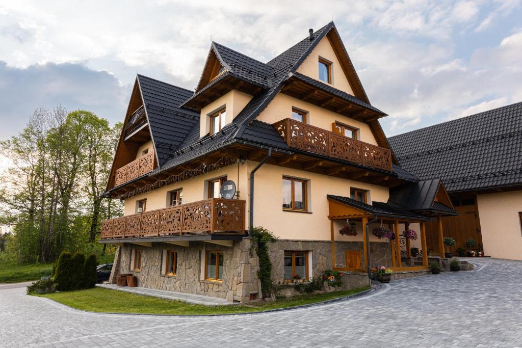 uma casa grande com um telhado preto em Zielony Szlak em Kościelisko