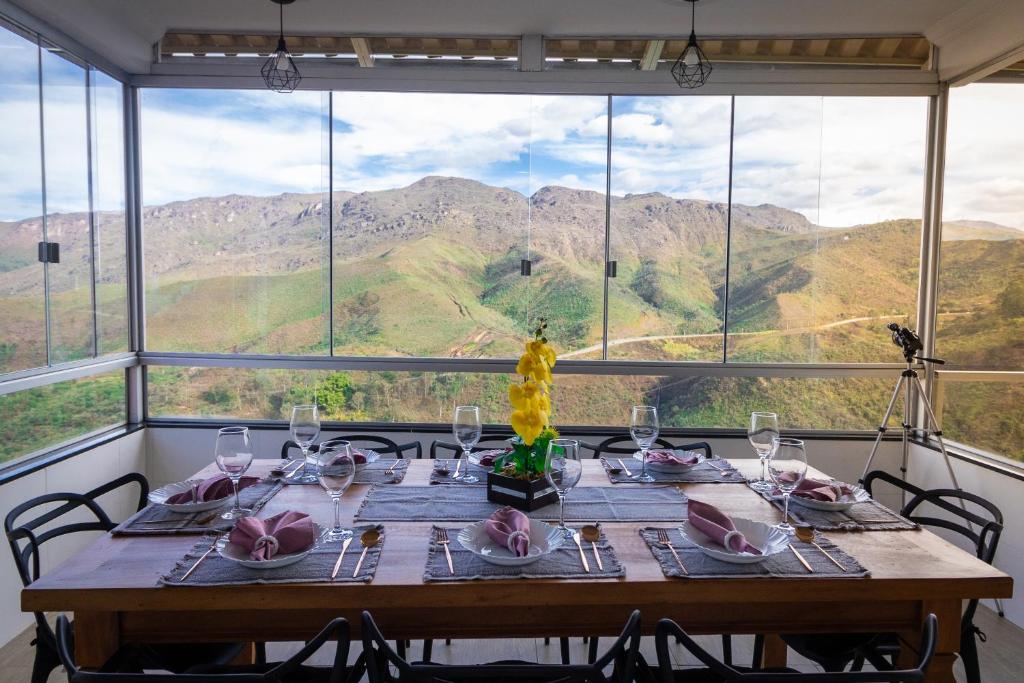 uma mesa com copos de vinho e vista para as montanhas em Até 8 Hóspedes, Linda Vista, Piscina, Salão de Jogos e Brinquedoteca em Ouro Preto