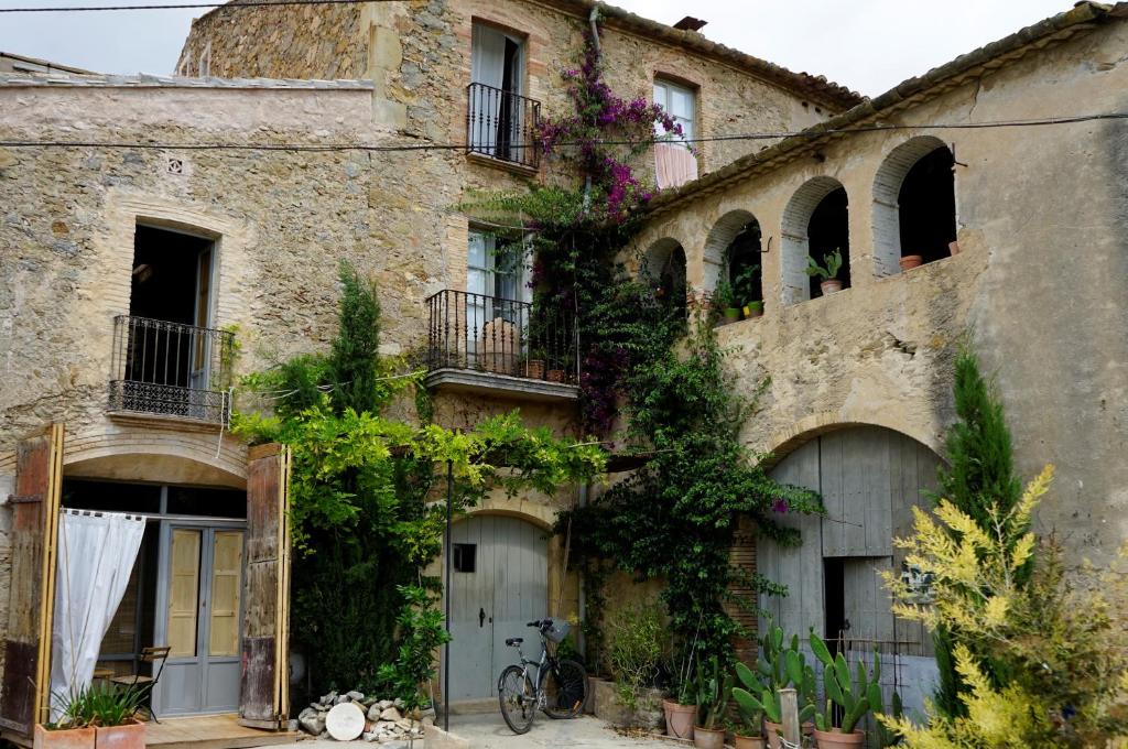 an old stone house with a bicycle parked in front of it at CAN TAT, Loft in a old coach house in Sant Jordi Desvalls