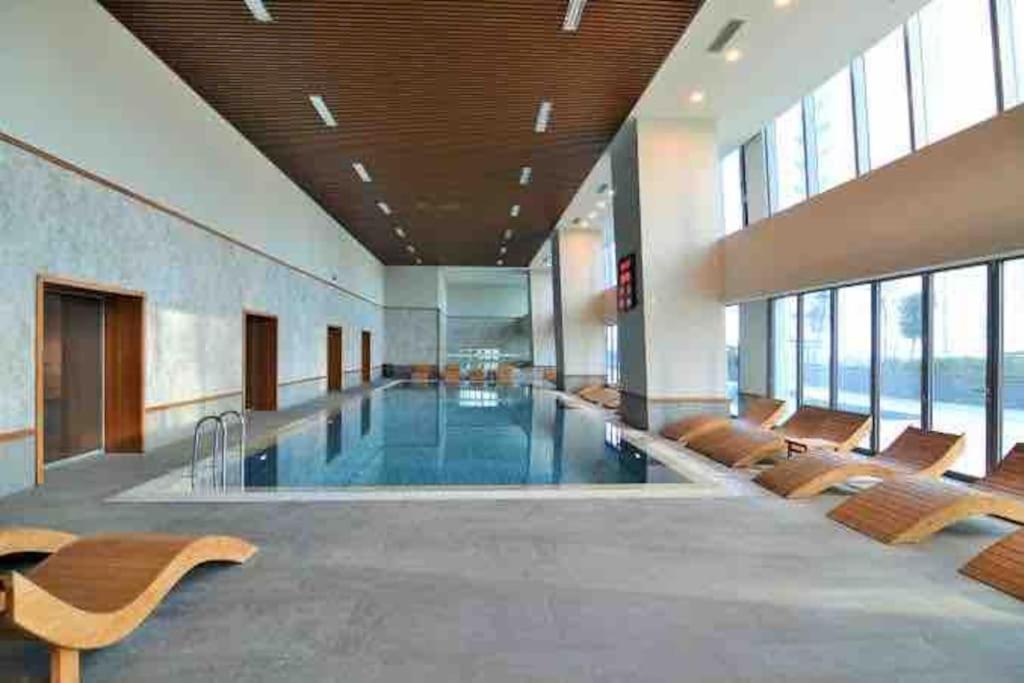 a large lobby with a pool with benches and windows at SKYLAND SKY DELUXE RESIDENCE in Istanbul