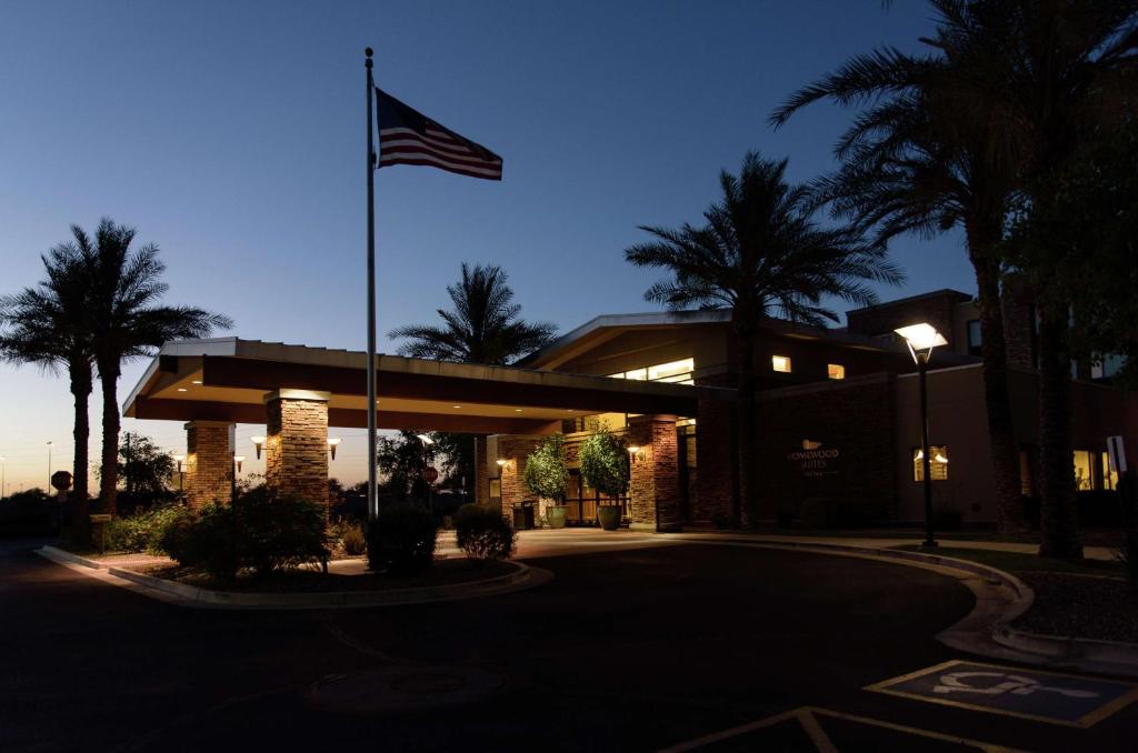 a flag flying in front of a building with palm trees at Homewood Suites by Hilton Phoenix Chandler Fashion Center in Chandler